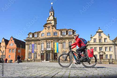 woman on bicycle tour in downtown of Schwaebisch Hall, one of the most famous  medieval cities in Germany 