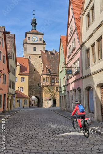 woman on bicycle tour in downtown of Rothenburg on Tauber, one of the most famous medieval cities in Germany 