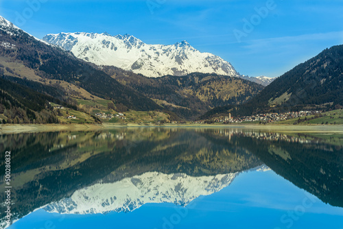 Panoramic view of the lake in the mountains. With the village of Resia, Reschen in South Tyrol, Südtirol, Trentino Alto Adige, Italia, Europa © Simone