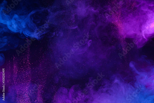 Colorful clouds of smoke and shiny glitter particles bursts abstract cosmic background © nevodka.com