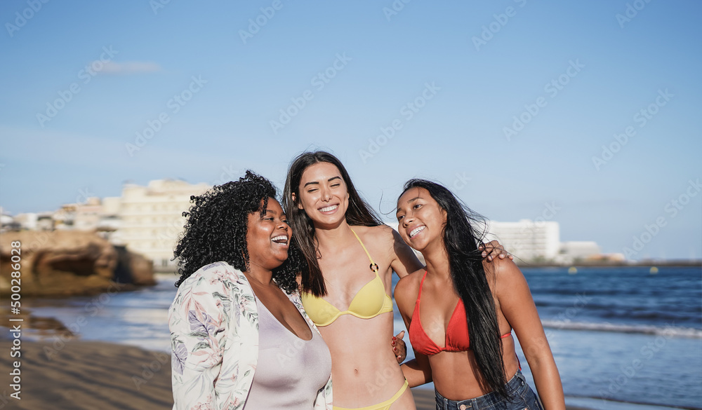 Happy multiracial women having fun on the beach - Concept of diversity and travel