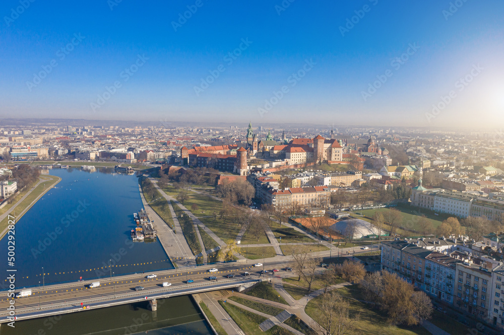 Blue tram rides over Grunwaldzki bridge at Vistula river,  Wawel castleat the background in Cracow ( Krakow), Poland. relaxed morning mood aerial photo