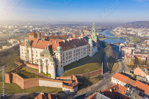Aerial drone view to Wawel castle on the hill and wisla river. Beautiful morning sunrise. City panaramic drone view from above. Poland Krakow famous tourist historical attractions. Sunny spring 