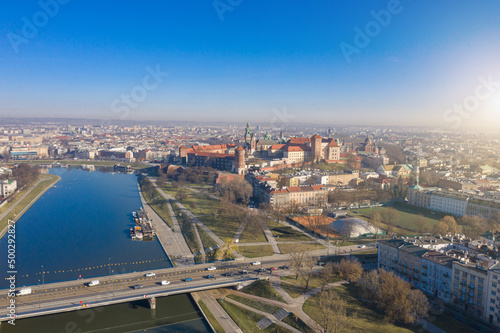 Blue tram rides over Grunwaldzki bridge at Vistula river, Wawel castleat the background in Cracow ( Krakow), Poland. relaxed morning mood aerial photo