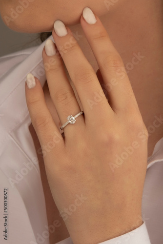 Beautiful lady's hand. woman wearing a white blouse and a diamond ring on her finger.