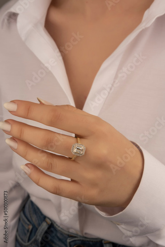 Beautiful lady's hand. woman wearing a white blouse and a diamond ring on her finger.