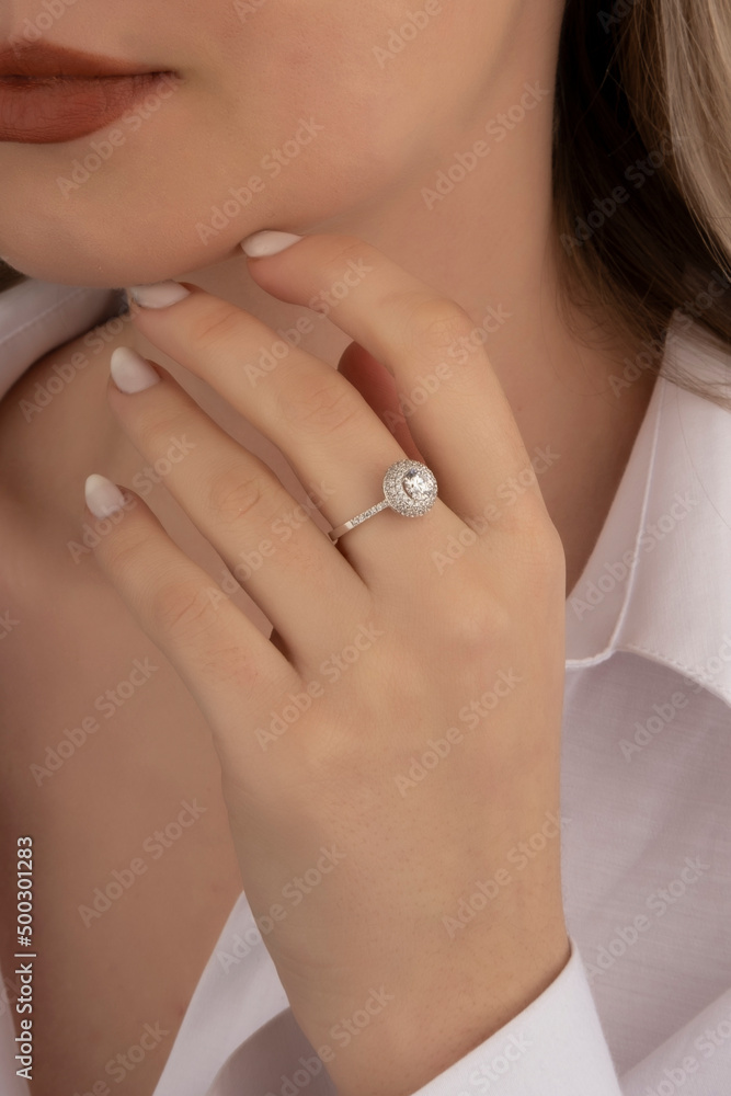 Beautiful lady's hand. woman wearing a white blouse and a diamond ring on her finger. Beautiful lady's hand. woman wearing a white blouse and a diamond ring on her finger.