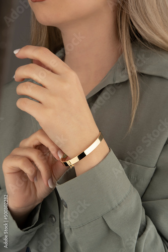 women s gold bracelet on the girl s hand  women s accessories  jewelry  gold bracelet with stones  women s jewelry  a girl with a bracelet on her arm  a bracelet with stones