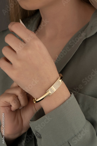 women's gold bracelet on the girl's hand, women's accessories, jewelry, gold bracelet with stones, women's jewelry, a girl with a bracelet on her arm, a bracelet with stones © Oguz