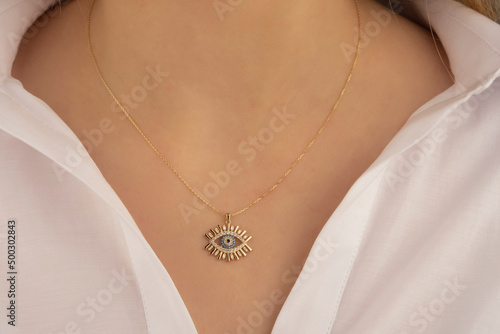 Beautiful model brunette curly hair woman on modern gold metal necklace chain