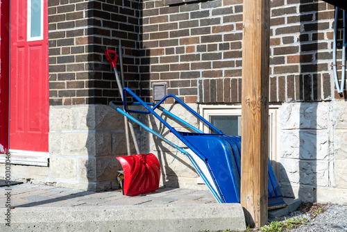 Snow shovels stacked at a backdoor in spring, waiting to be putaway until next winter. photo