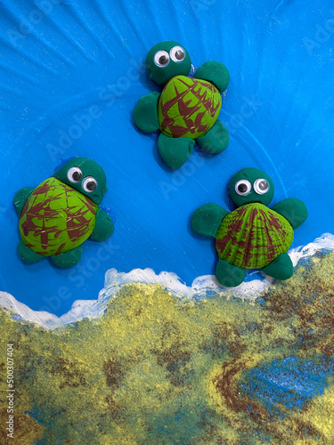 Three handmade turtles made from recycled materials. Vertical