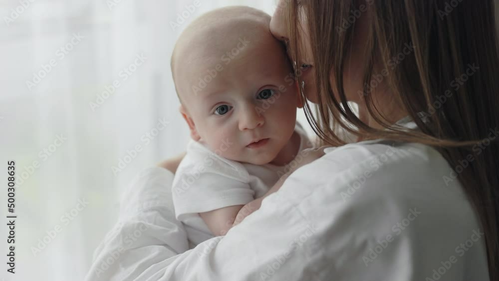 Woman embracing and kissing her newborn son at home Woman embracing and kissing her newborn son at home