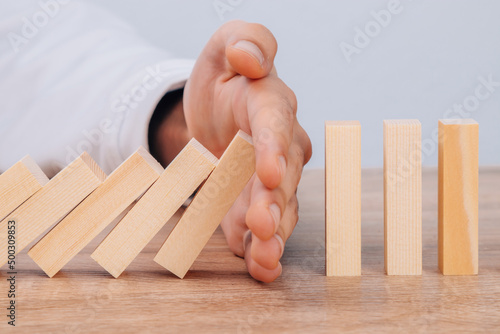 hand stops falling pieces, business concept photo