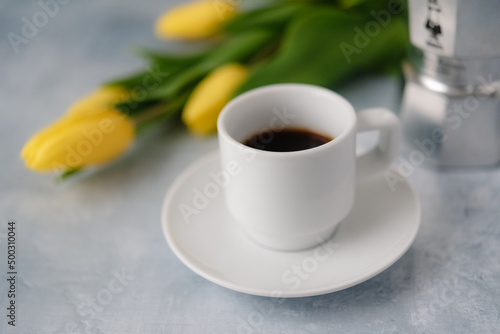 Cup of coffee with yellow flowers