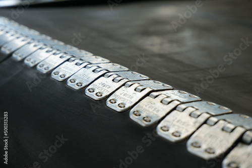 Close-up of a rubber conveyor belt connected by a flexible metal joint.Selective focus.