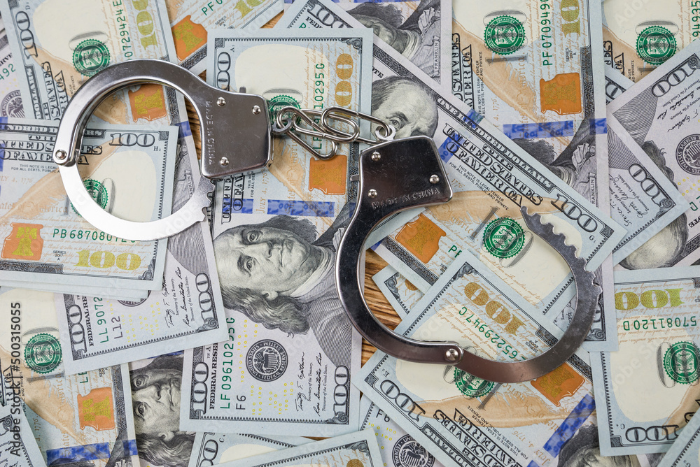 metal handcuffs on dollars background metal handcuffs on dollars background
