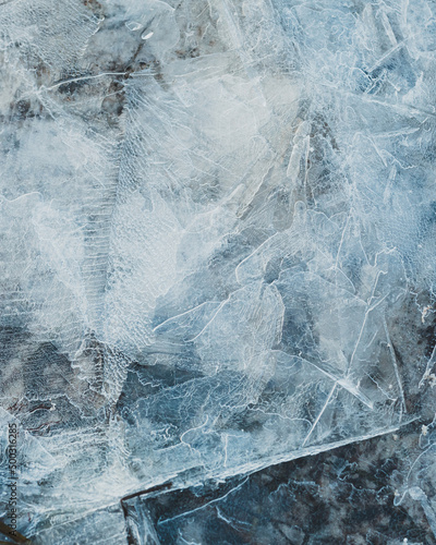 cracked ice close up, deep frozen lake blue ice texture, repeating pattern