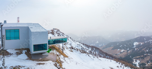 View of alpine museum and restaurant on snowy landscape. Panoramic sight of converted funicular station on mountain range in alps . Tourist attraction against sky during winter.