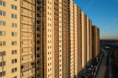 empty unfinished apartment building made of concrete near the road from bottom to top view. High quality photo