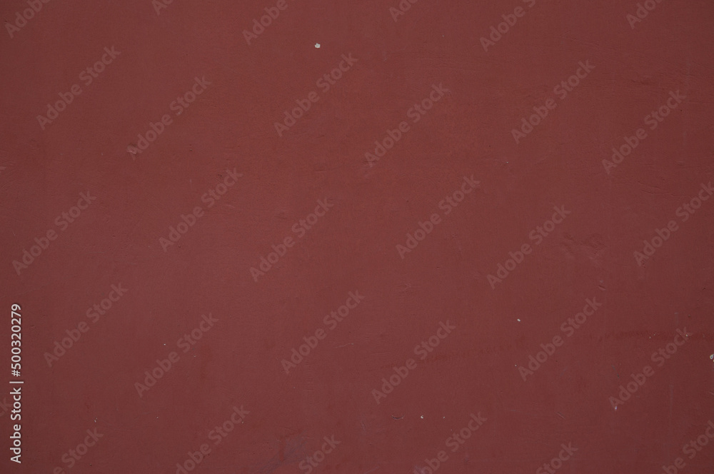Old maroon concrete painted wall background Old maroon concrete painted wall background