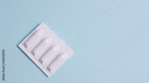 Suppository for anal or vaginal use on a blue background. Candles for treatment of hemorrhoids, temperature, thrush, inflammation. photo
