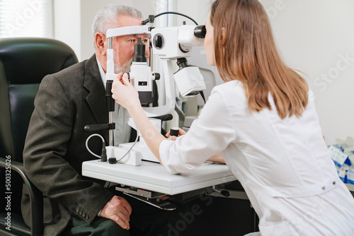 Valokuva ophthalmologist examination of elderly man with slit lamp
