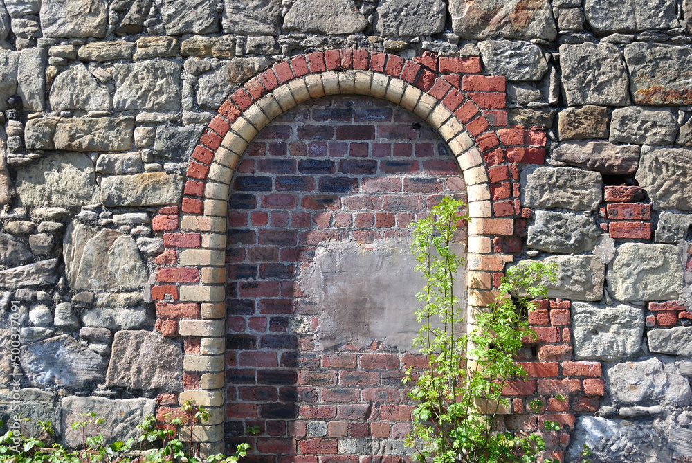 Old Stone Wall with Sealed Arched Brick Entrance 