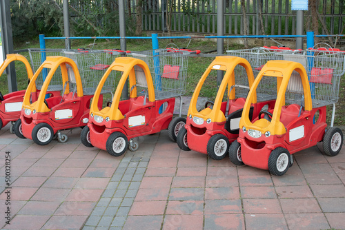 Children's strollers shaped like colorful red and yellow cars