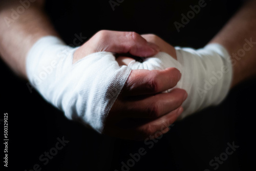 Hands of a boxer with white bandages prepared to fight in a sport battle