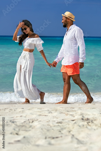 Attractive loving young Cuban couple on a beach.