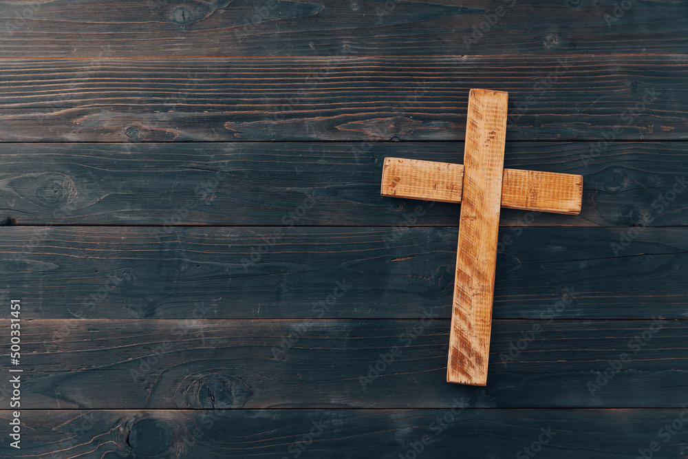 Christian cross on wooden background