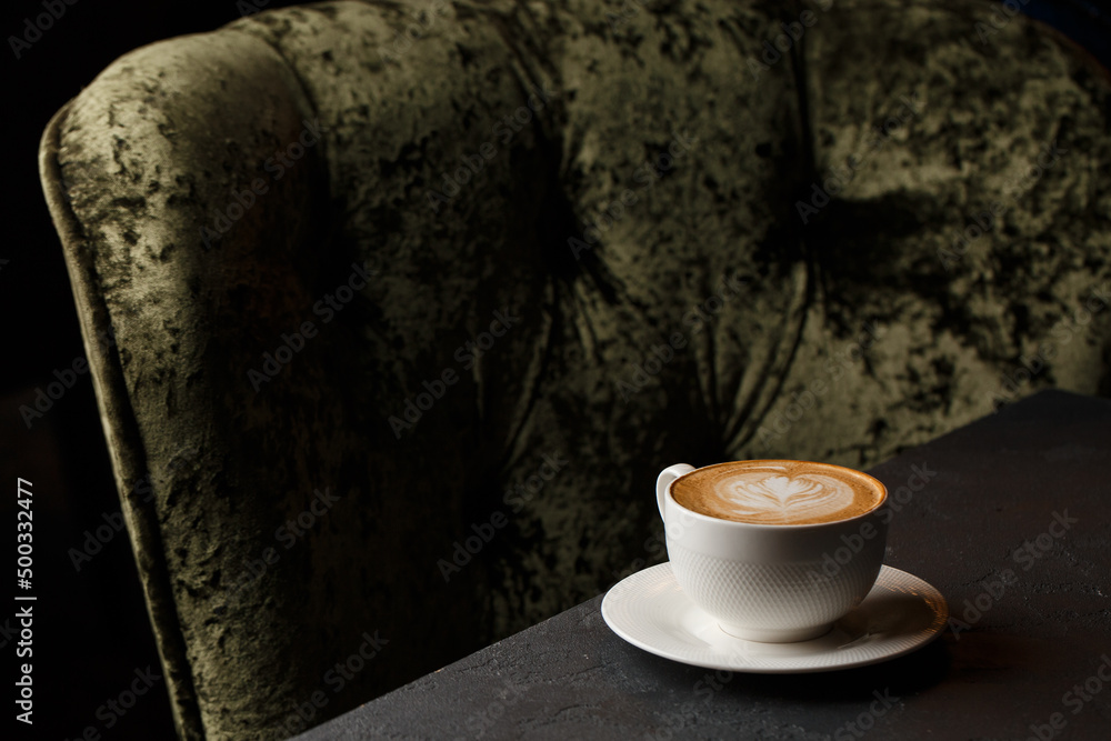 White cup of hot latte coffee with beautiful milk foam latte art texture isolated on dark background. Overhead view, copy space. Coffee shop menu.