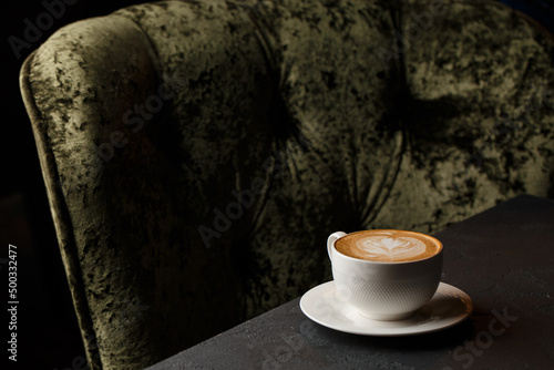 Obraz na płótnie White cup of hot latte coffee with beautiful milk foam latte art texture isolated on dark background. Overhead view, copy space. Coffee shop menu. w salonie