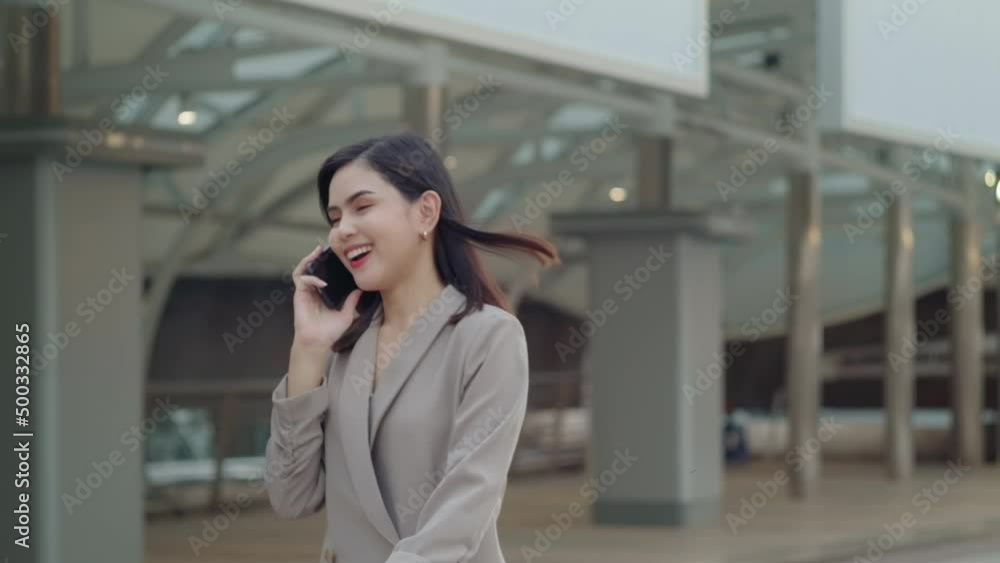 A young beautiful businesswoman is using Smart phone in Modern city , business technology , city lifestyle concept A young beautiful businesswoman is using Smart phone in Modern city , business technology , city lifestyle concept