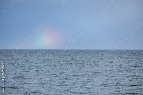 Blue sky, ocean and rainbow spot