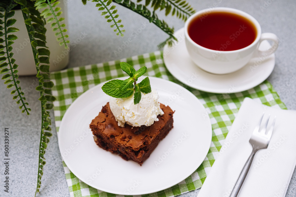 brownie portion with a ball of vanilla ice-cream on top. American traditional pastry. Cocoa powder and chocolate are main ingredients. brownie portion with a ball of vanilla ice-cream on top. American traditional pastry. Cocoa powder and chocolate are main ingredients.