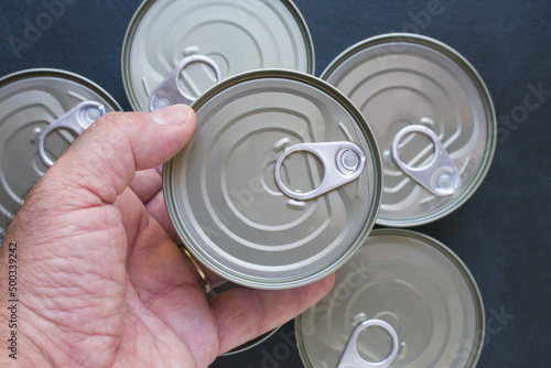 Foto Mature man hand holding a can with canned food top view.