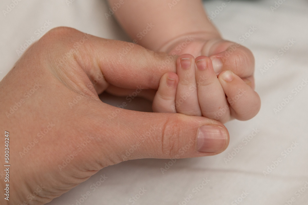 mother holds the baby by the hand mother holds the baby by the hand