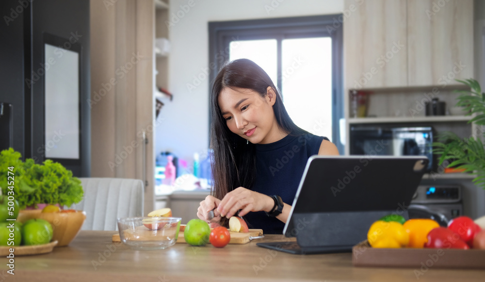 Young vegetarian woman preparing healthy vegan food in kitchen. Healthy food lifestyle concept.