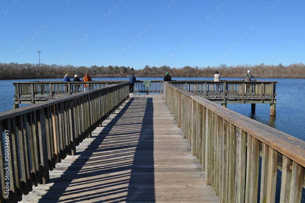 People standing on the fishing pier, White Lake, Cullinan Park Conservatory, Sugar Land, Texas