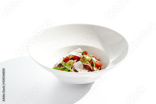 Roast beef and grilled vegetables salad isolated on white background. Steak salad with pastrami, eggplant, tomato, remoulade sauce with parmesan flakes. Gourmet dish with grilled meat and vegetables.