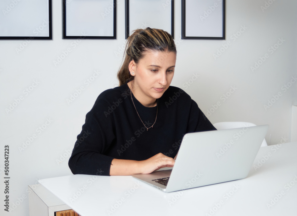 Beautiful woman sitting in front of her laptop computer Beautiful woman sitting in front of her laptop computer