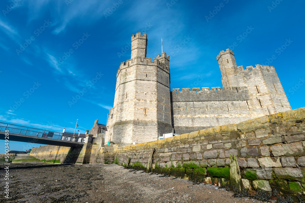 Caernarfon Castle,low angle view of sea walls,from banks of the River Seiont at low tide,Wales,United Kingdom.