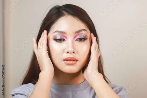 Conceptual beauty portrait of a beautiful young woman with colorful eyeshadow