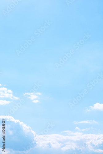 Soft fluffy cumulus clouds above the light blue sky in sunny day. Purity of natural white cloudscape scene with copy space. Vertical background. Freedom and calm of nature concept. Outdoor fresh air.