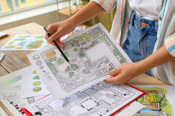 Young female landscape designer working in office