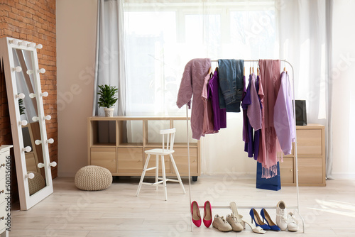 Rack with stylish clothes and shoes in modern dressing room © Pixel-Shot