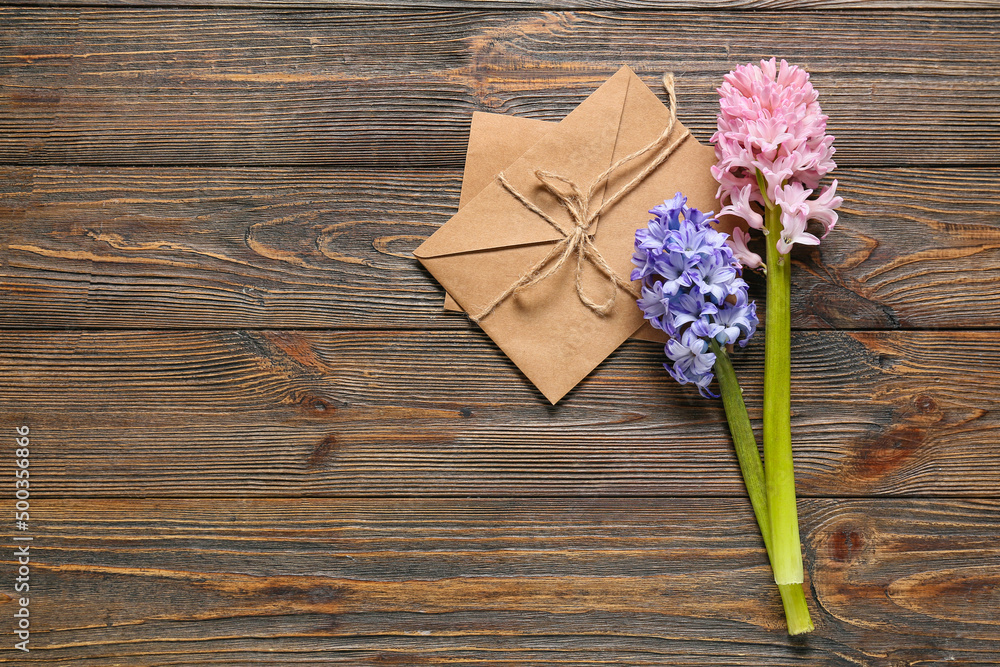 Envelope and beautiful hyacinth flowers on wooden background
