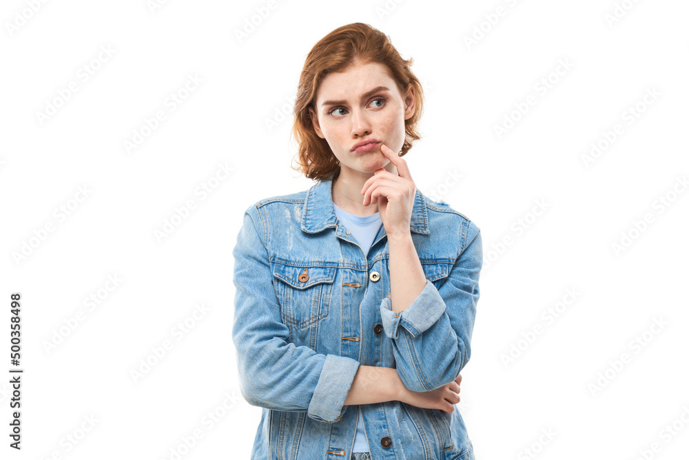 Smart redhead girl in casual holding chin thinks doubts, makes decision isolated on white studio background Smart redhead girl in casual holding chin thinks doubts, makes decision isolated on white studio background